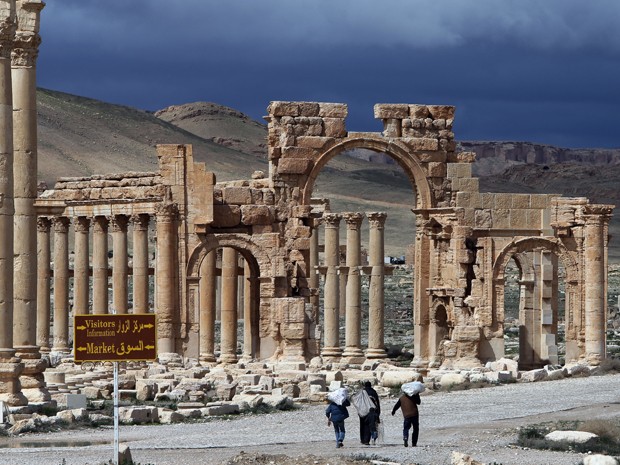 Em foto de 14 de março de 2014, sírios caminham pela antiga cidade de Palmira, a 215 quilômetros de Damasco (Foto: AFP Photo/Joseph Eid)