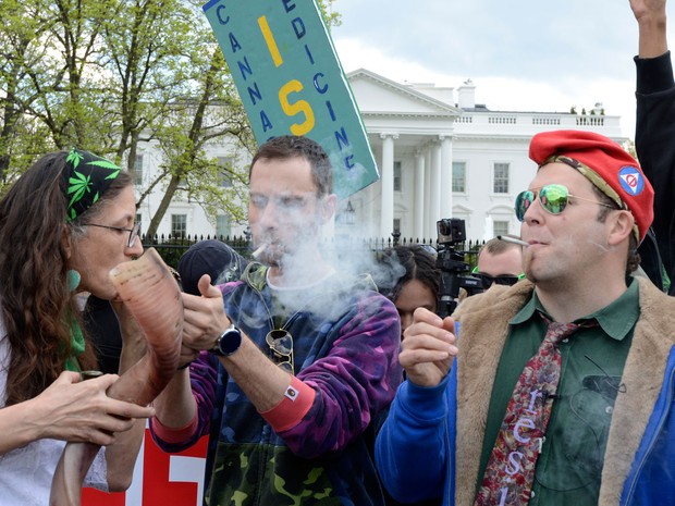 Defensores da reclassificação da maconha fumam em frente à Casa Branca, durante manifestação no sábado (2) (Foto: AFP Photo/Mike Theiler)