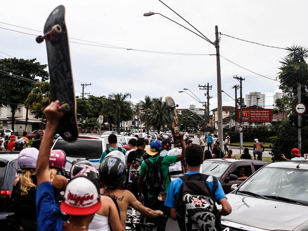 Fã levanta o skate ao acompanhar a passagem do carro com o caixão (Foto: Luiz Fernando Menezes / Fotoarena / Estadão Conteúdo)