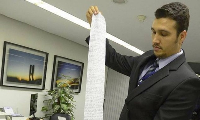 Funcionário segura o pedido de habeas corpus escrito em papel higiênico (Foto: Divulgação / STJ)