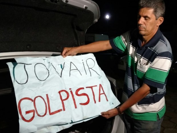 Secretário-geral do partido em Goiás mostra faixa levada por manifestantes em Goiás (Foto: Reprodução/ TV Anhanguera)