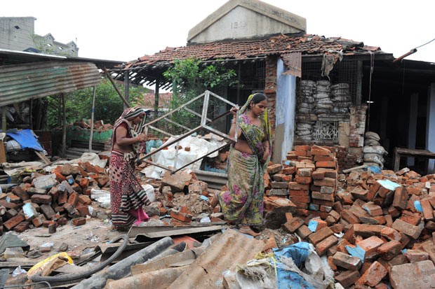 Moradores observam suas casas destruídas pela chuva em Bapunagar, região de Ahmedabad, neste domingo (14) (Foto: Sam Panthaky/AFP)
