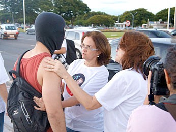 Mãe do jovem assassinado em Águas Claras conversa com um rapaz mascarado que se juntou ao restante do grupo (Foto: Ricardo Moreira / G1)