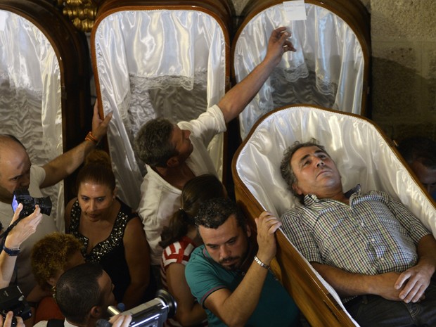 Homem é carregado por seus parentes durante a Procissão das Mortalhas, em Santa Marta de Ribarteme, na Espanha, na quarta (29) (Foto: AFP Photo/Miguel Riopa) Homem é carregado por seus parentes durante a Procissão das Mortalhas, em Santa Marta de Ribarteme, na Espanha, na quarta (29) (Foto: AFP Photo/Miguel Riopa)