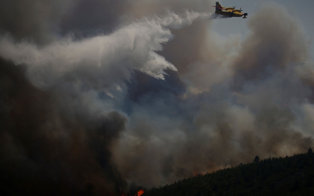 Avião joga água para combater incêndio que atinge a floresta de Cadafaz, perto de Góis, nesta terça-feira (20)  (Foto: Rafael Marchante/ Reuters)