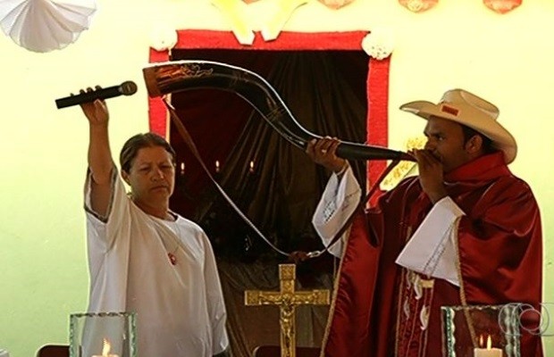 Padre Adão Soares toca berrante em celebração de missa em Formosa, Goiás (Foto: Reprodução / TV Anhanguera)