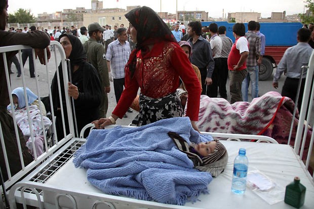 Iraniana cuida da filha ferida apos terremoto do lado de fora de hospital em Ahar, a 60 km de Tabriz (Foto: Kamel Rouhi / AFP)