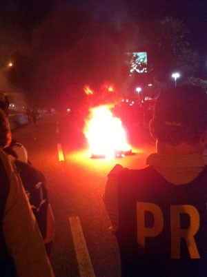 Policiais rodoviários observam manifestantes ateando fogo em pneus em Natal (Foto: Felipe Gibson)