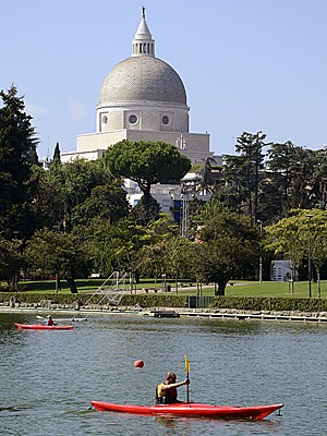 Pessoas andam de caiaque em parque do bairro EUR, em Roma, com vista para a Basílica de São Pedro (Foto: Michele Barbero/AP)