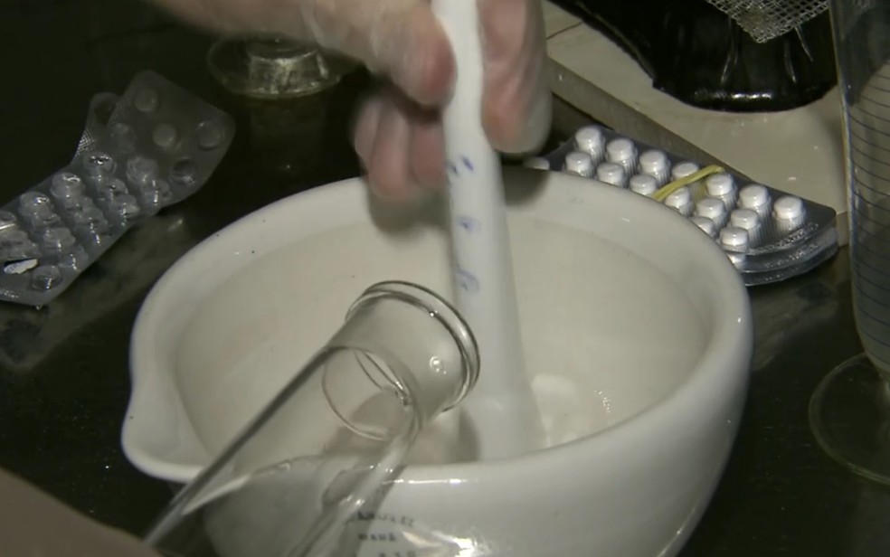 Funcionária diluindo comprimido em xarope de água e açúcar (Foto: TV Globo/Reprodução)