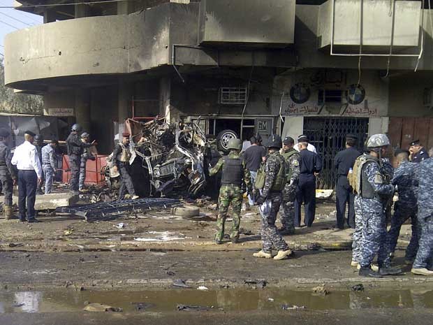 Investigadores inspecionam local de um ataque produzido por um carro-bomba em Bagdá. (Foto: Saad Shalash / Reuters)