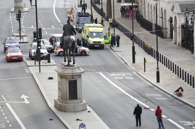 Homem não identificado ficou duas horas nu sobre estátua em Londres nesta sexta-feira (23) (Foto: Justin Tallis/AFP)