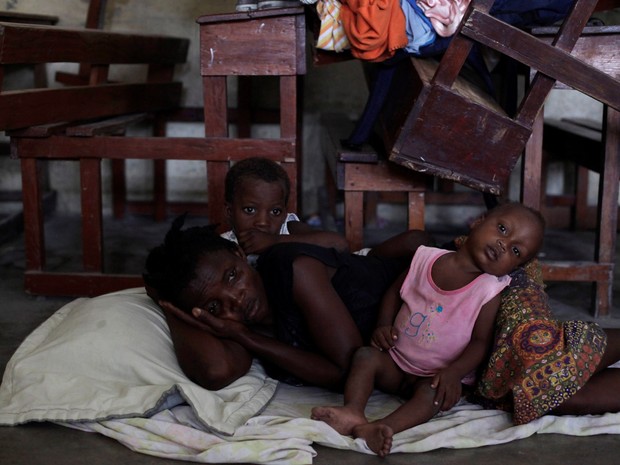 Uma mulher descansa ao lado de seus filhos no chão de um abrigo em Les Cayes, no Haiti, antes da passagem do furacão Matthew (Foto: Andres Martinez Casares/Reuters)