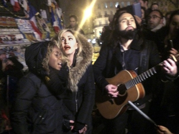 Madonna canta na Praça da República, em Paris, ao lado do guitarrista Monte Pittman e do filho dela David Panda (Foto: Jules Mahe/AFP )