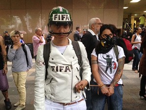Acorrentadas usam máscaras e capacetes com escrito "Fifa". (Foto: Isabela Marinho / G1) Acorrentadas usam máscaras e capacetes com escrito "Fifa". (Foto: Isabela Marinho / G1)