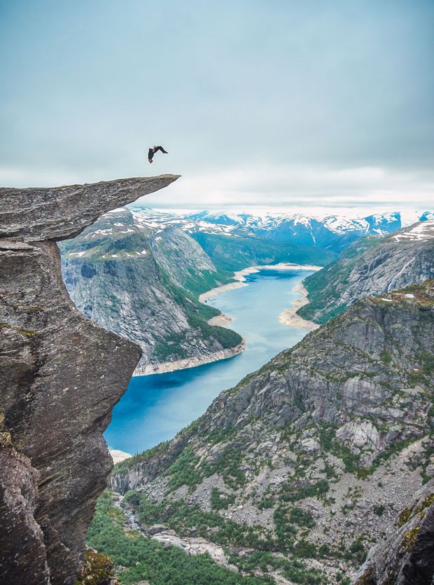 Toby Segar gira no ar em pirueta no momento em que dá um mortal para trás na rocha Trolltunga, na Noruega (Foto: Caters News/The Grosby Group)
