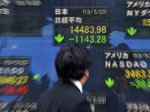 Homem observa índice da bolsa de Tóquio (Foto: AFP)