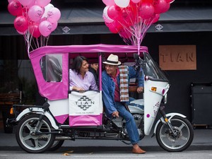 Marina Pipatpan e Cyro Sá, proprietários do restaurante, no triciclo motorizado (Foto: Victor Moriyama/Tian/Divulgação)