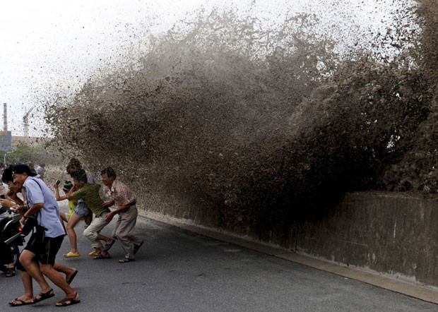 Curiosos foram atingidos por onda à beira do rio Qiatang. (Foto: Lang Lang/Reuters)