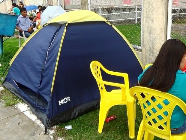Barrancas são usadas por pais e alunos enquanto aguardam a abertura dos portões da escola  (Foto: Reprodução/TV Cruzeiro do Sul)
