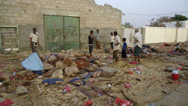 Moradores observam neste domingo (5) local do atentado suicida na cidade iemenita de Jaar (Foto: Reuters)