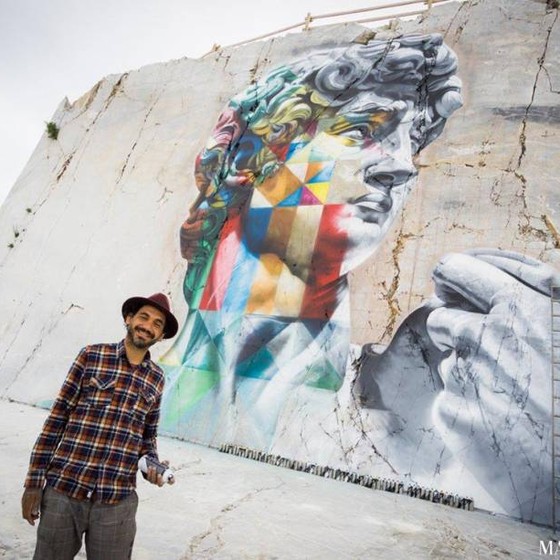 Kobra posa em frente ao seu novo mural em Carrara, na Itália, inspirado na obra Davi, de Michelangelo (Foto: Matteo Dunchi/Divulgação)