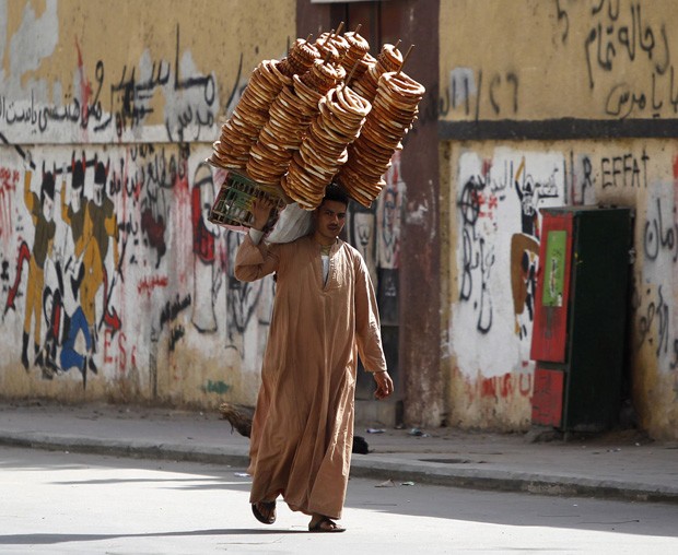 Vendedor de pão foi flagrado caminhando 'supercarregado' próximo à praça Tahrir, no Cairo (Foto: Amr Abdallah Dalsh/Reuters)