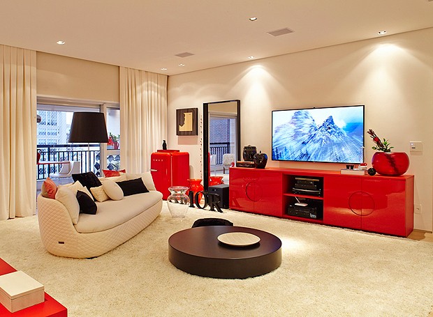 O quarto tem um espaço para a televisão, com direito a sofá, mesa de centro e frigobar (Foto: Victor Affaro)