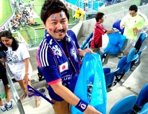 À frente, o orgulho da civilidade. Ao fundo, japonês pede a outro torcedor para jogar o lixo no saco (Foto: Chandy Teixeira/GloboEsporte.com)
