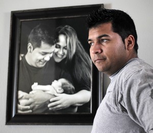 O Marido e Marlise, Erick Muñoz, diante de uma foto dos dois com o filho, Mateo (Foto: AP)