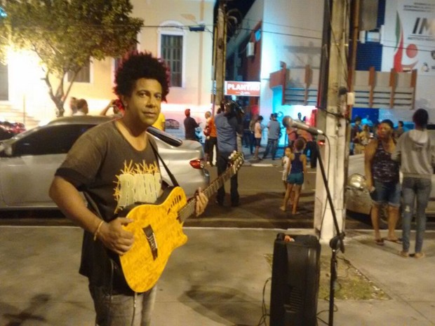 Cantor faz homenagem ao ator Domingos Montagner na porta do IML de Aracaju (Foto: Priscilla Bitencourt/TV Sergipe)