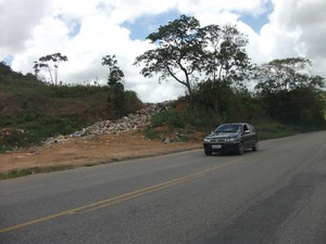 Em Porto Calvo, resíduos do lixão que está abarrotado chega até a rodovia AL-465 (Foto: Waldson Costa/ G1)