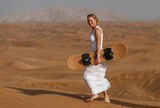 De vestido longo, Caroline Wozniacki faz sandboard no deserto em Dubai