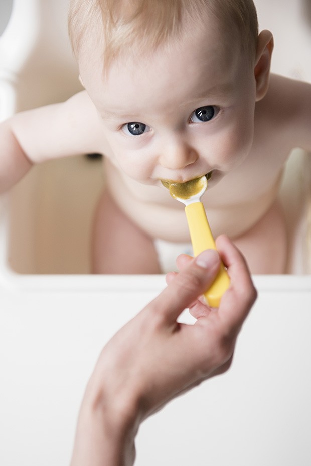 Caucasian mother feeding baby son with spoon in high chair (Foto: Getty Images/Blend Images)