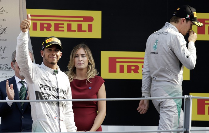 Lewis Hamilton comemora, enquanto Nico Rosberg sai de fininho do pódio no GP da Itália (Foto: Reuters)