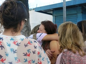 Mãe da vítima é confortada por amigos e familiares (Foto: Natasha Guerrize/G1)