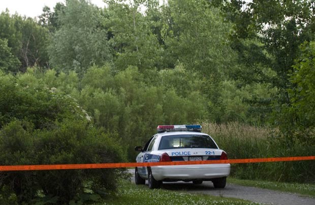 CArro da polícia no local onde os restos humanos foram achados em parque em Montreal neste domingo (1º) (Foto: AFP)