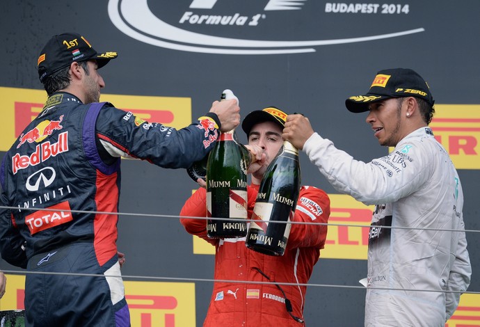 Daniel Ricciardo, Fernando Alonso e Lewis Hamilton brindam no pódio do GP da Hungria (Foto: AFP)
