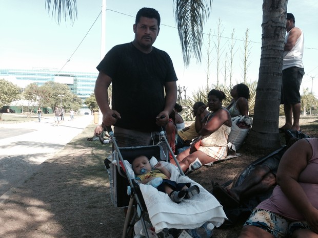 Carlos Alessandro, 34 anos, aguarda autoridades com o filho de dois meses. (Foto: Matheus Rodrigues / G1)