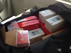 Suspeitos chegaram a separar várias caixas, mas nada foi levado no assalto a loja de celulares em Mogi. (Foto: Carolina Paes/G1)