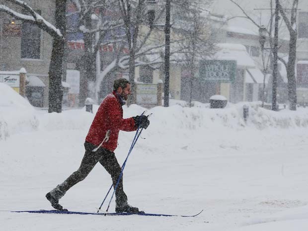 Homem anda de esqui por rua coberta de neve em Brookline, Massachusetts  (Foto: REUTERS/Brian Snyder)
