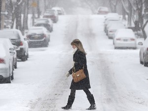 Mulher atravessa rua vazia na cidade de Albany, no estado de Nova York, EUA, nesta quinta-feira (Foto: AP Photo/Mike Groll)
