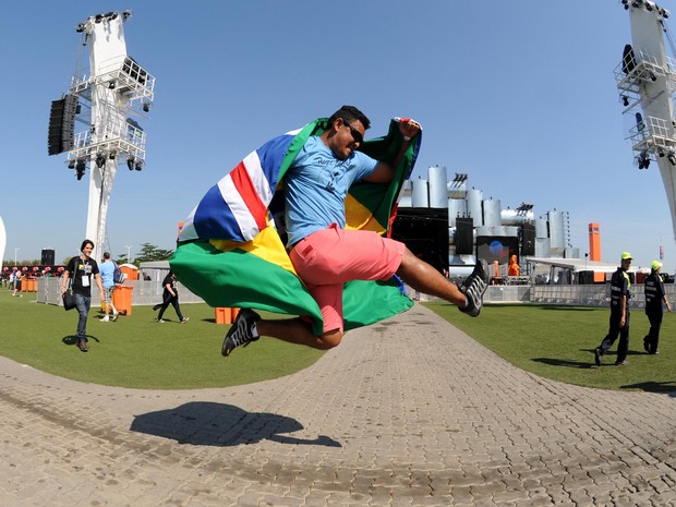 Fã de rock salta em frente ao palco Mundo, com bandeiras do Brasil e do Reino Unido nas costas (Foto: Alexandre Durão/G1)