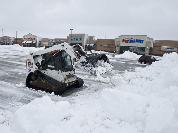 Operário trabalha para limpar a neve de um estacionamento após tempestade de neve atingir o centro-oeste dos EUA em Merriam, Kansas. (Foto: Julie Denesha/Getty Images/AFP)