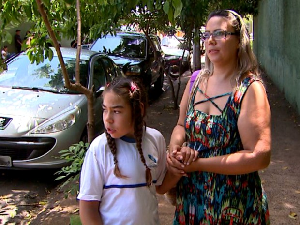Sem professor de apoio, Kauana Pacheco, de 11 anos, fica apenas meio período na escola. Ao seu lado, a mãe Ângela Carine Pacheco (Foto: Ronaldo Gomes/EPTV)