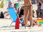 Cynthia Howlett exibe barriga trincada e pernas torneadas em praia do Rio