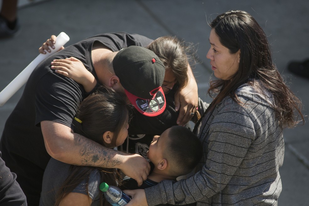 Parentes de alunos da escola North Park, em San Bernardino, buscam filhos após homem armado disparar em sala de aula nesta segunda-feira (10) (Foto: DAVID MCNEW / GETTY IMAGES NORTH AMERICA / AFP)