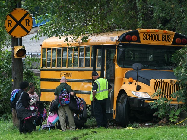 Mochilas dos alunos são retiradas de ônibus escolar após o acidente que matou a motorista Laura Zborowski em Akron, Ohio (Foto: AP Photo/Akron Beacon Journal, Ed Suba Jr)