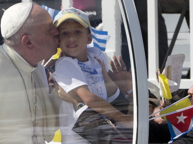 Papa Francisco beija criança ao chegar à Praça da Revolução de Holguín, em Cuba, para celebrar missa nesta segunda-feira (21) (Foto: Alessandra Tarantino/AP)