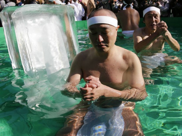 Homem mergulha com blocos de gelo em piscina durante ritual de inverno no Japão (Foto: Toru Hanai/Reuters)